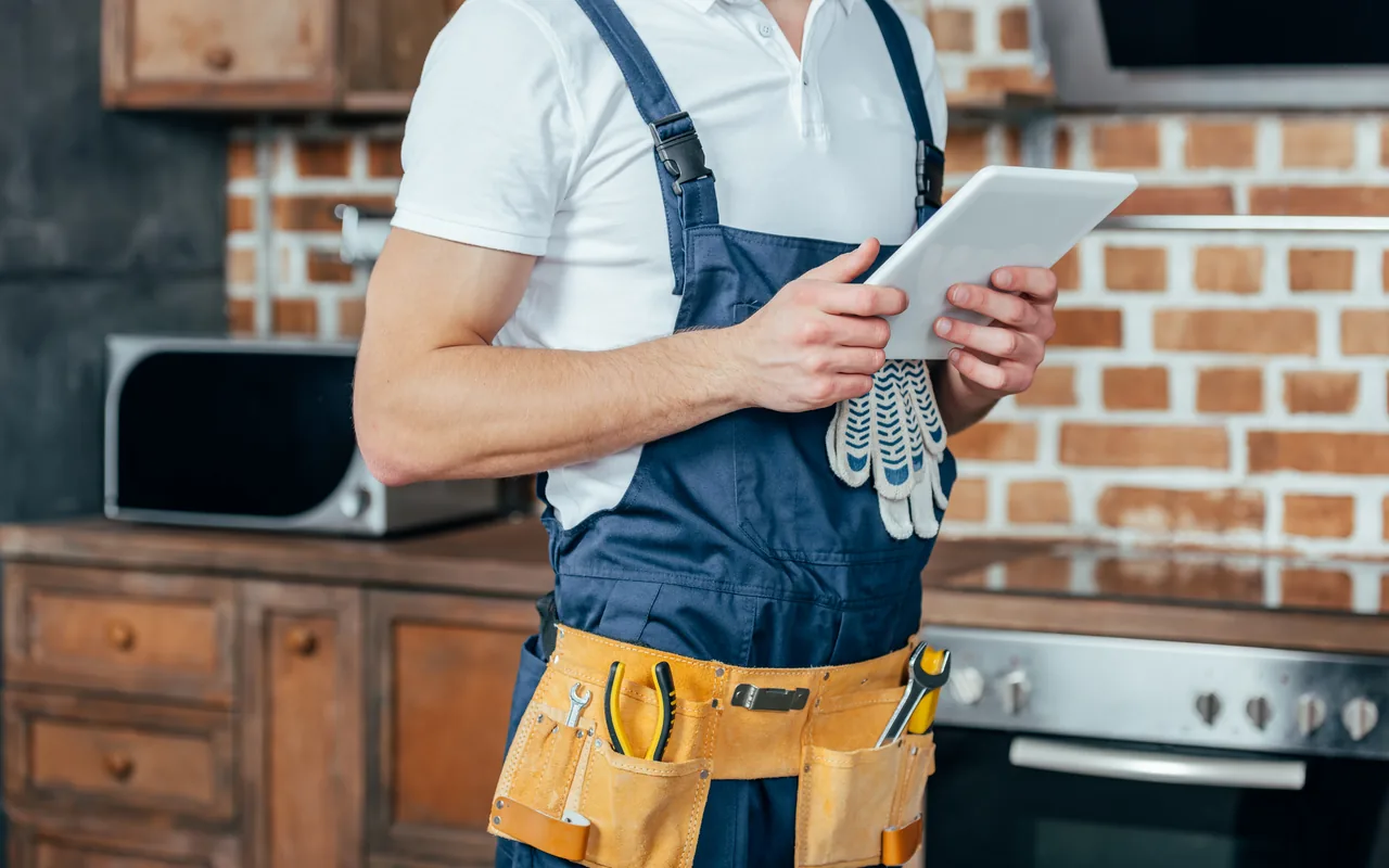Maintenance professional using a tablet while working in a home