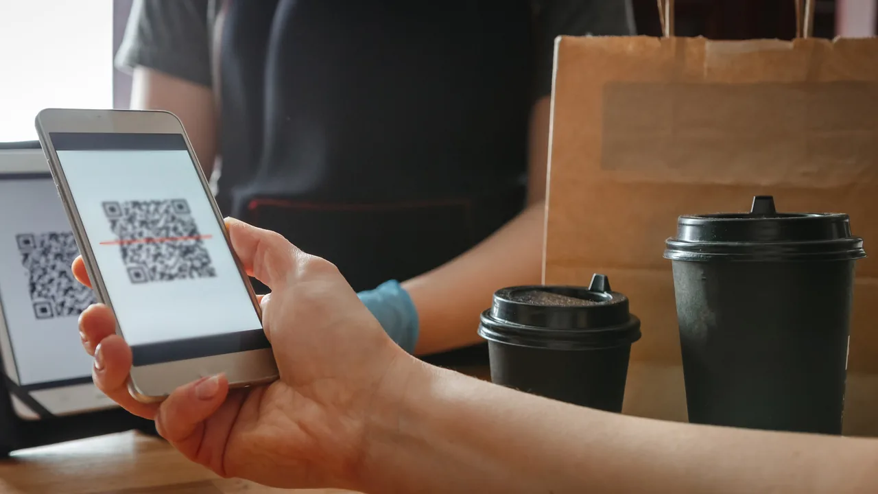 Customer scanning a QR code at a café counter